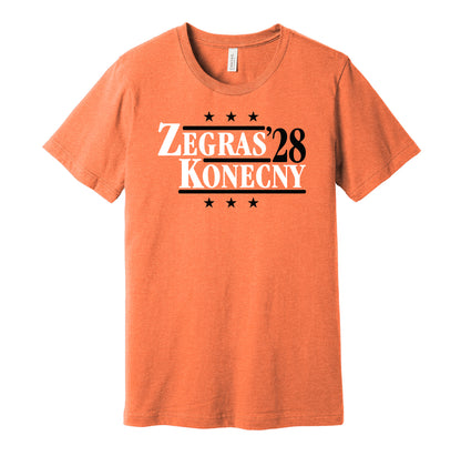 Philadelphia Flyers retro political campaign parody orange t-shirt featuring Trevor Zegras and Travis Konecny '28, designed in a vintage election style by Hyper Than Hype Shirts.