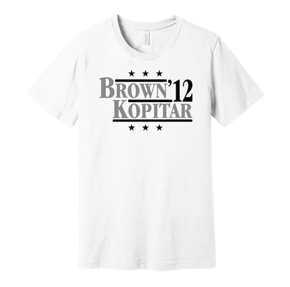 Los Angeles Kings retro political campaign parody white t-shirt featuring Dustin Brown and Anze Kopitar '12, designed in a vintage election style by Hyper Than Hype Shirts.